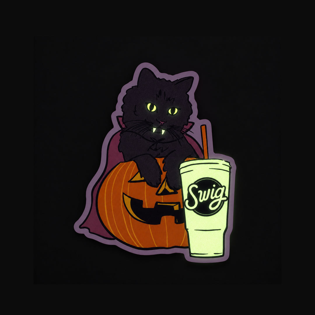 The black cat sticker glowing green in the dark.
