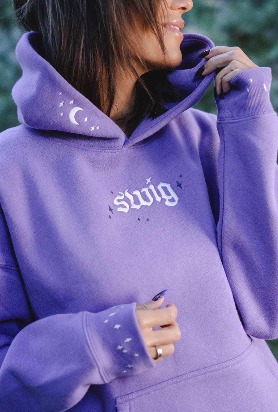Close view of a lavender Swig hoodie with its crescent moon hood and star-patterned cuffs.